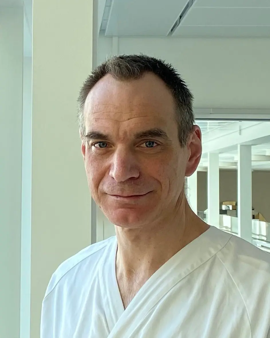 En mann som smiler til kameraet