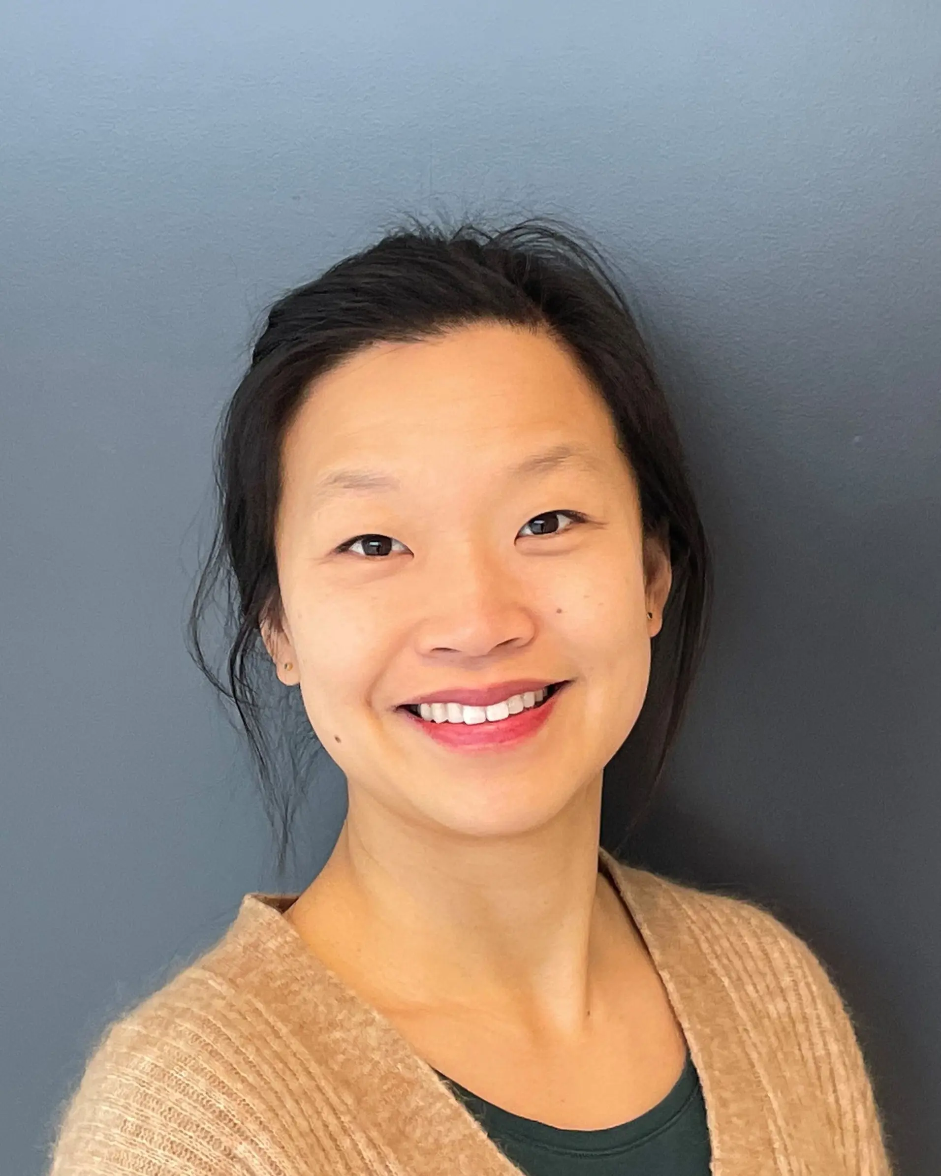 En kvinne som smiler til kameraet