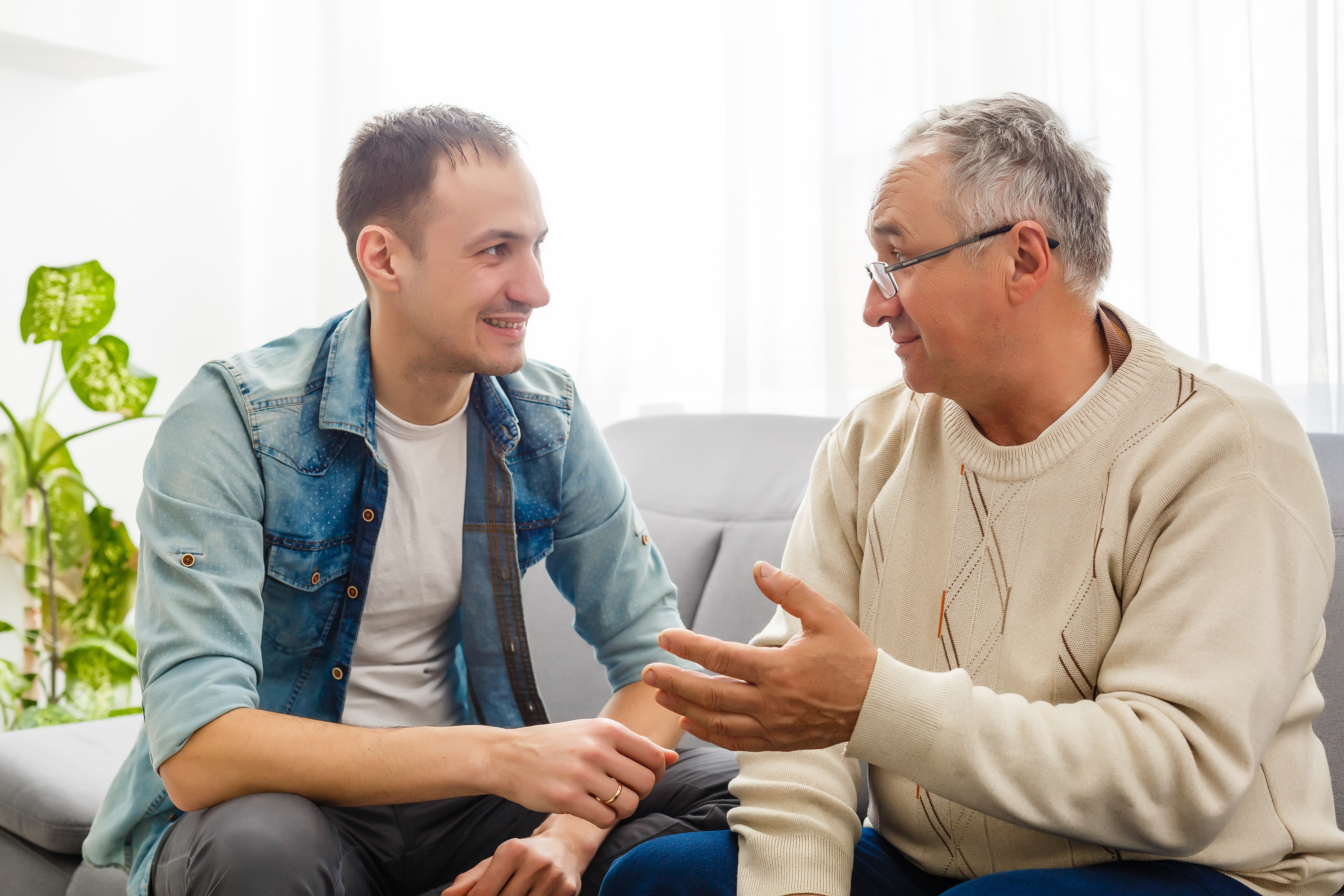 To menn sitter i en sofa og prater