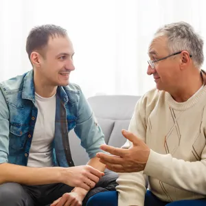To menn sitter i en sofa og prater