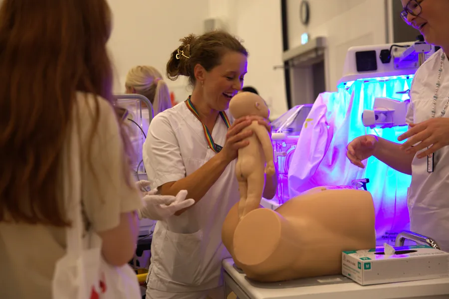 Babydukken er født og undersøkes av jordmor