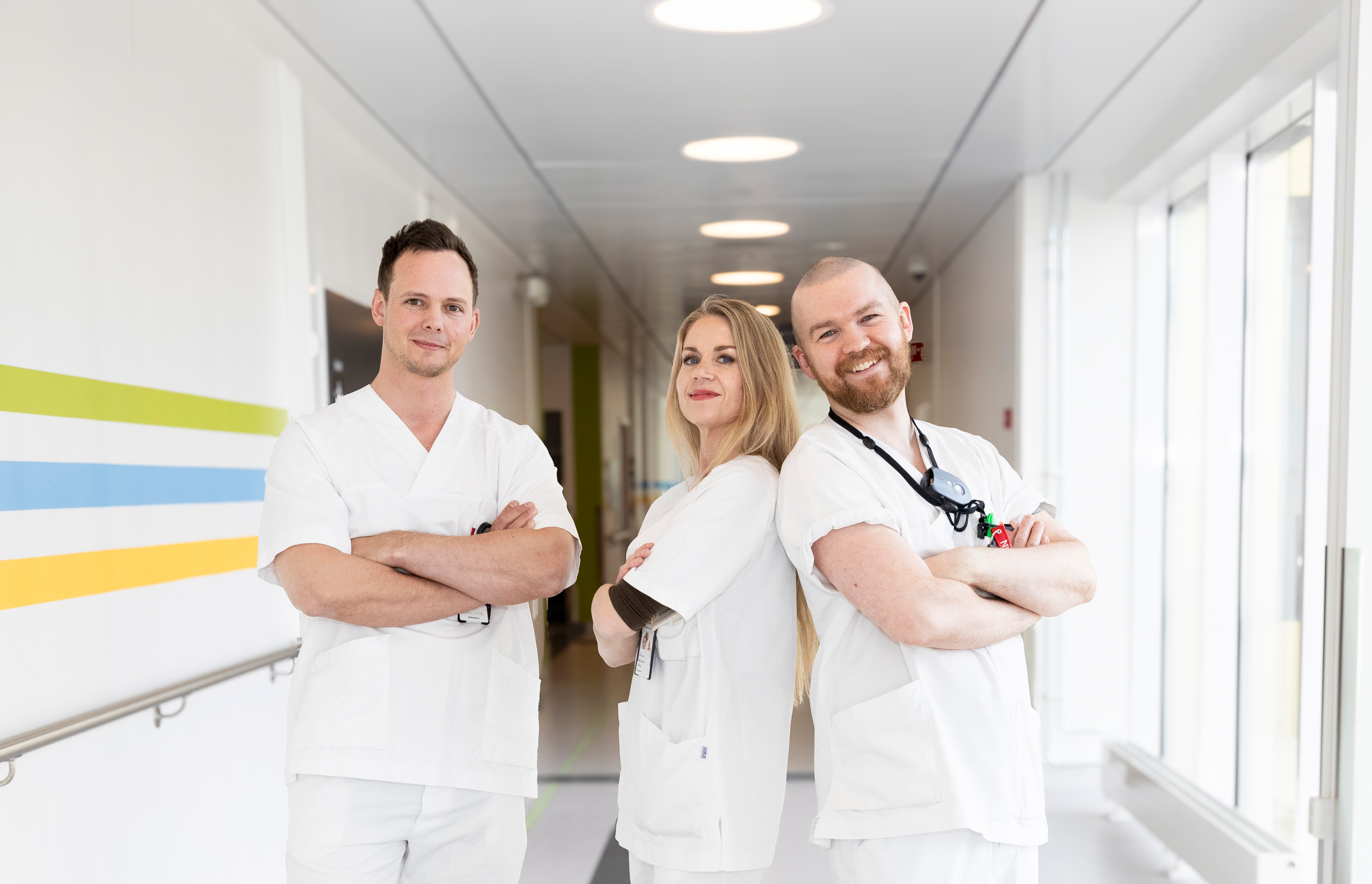 Tre sykepleiere i en korridor