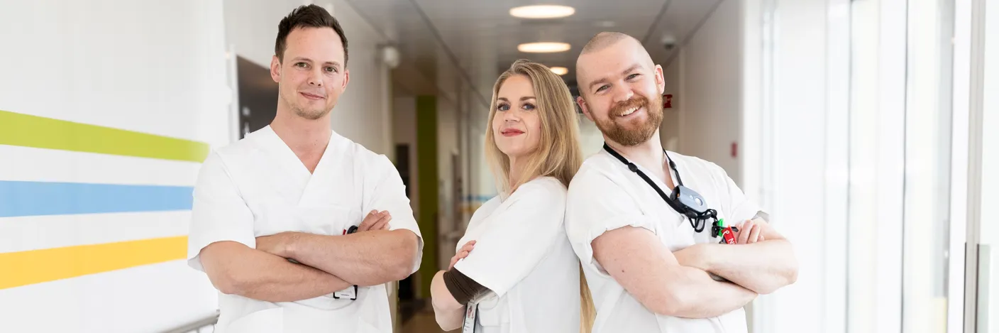 Tre sykepleiere i en korridor