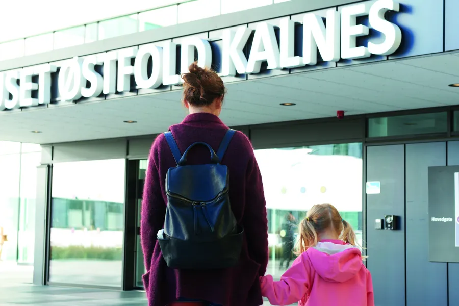 Illustrasjon: En mor og datter går mot hovedinngangen på Kalnes