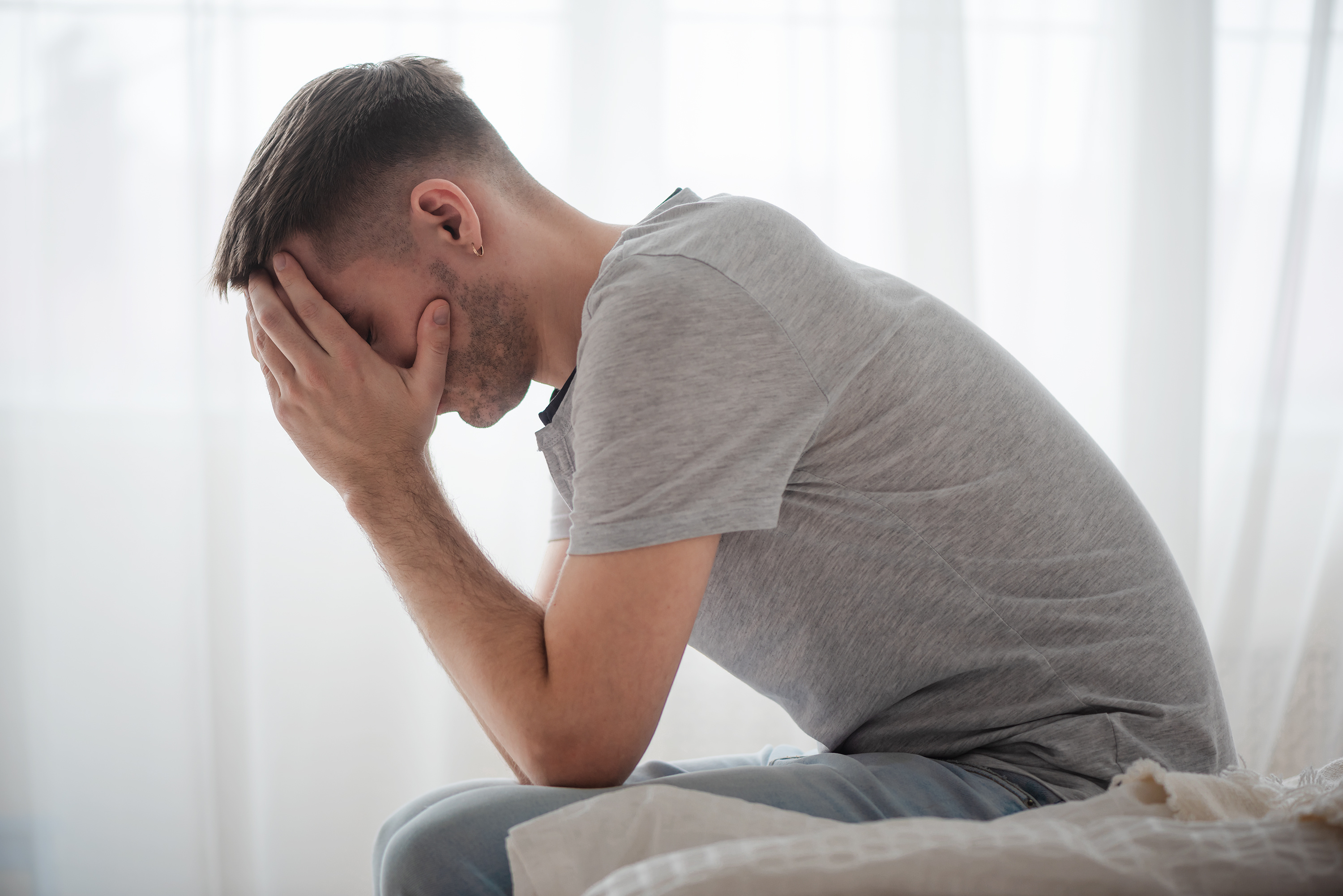 En mann med hånden over ansiktet