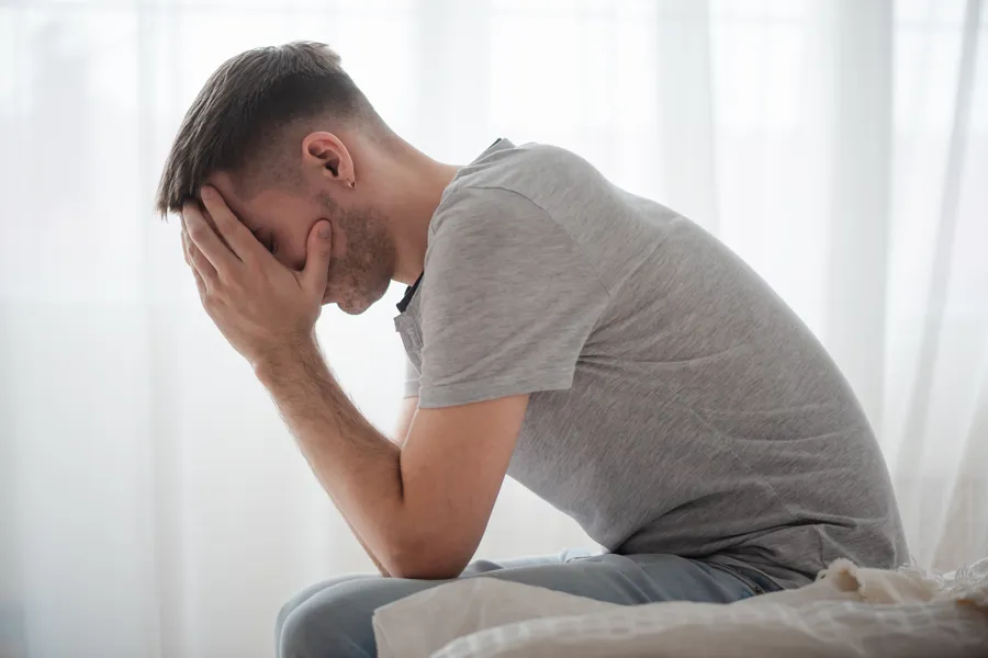 En mann med hånden over ansiktet