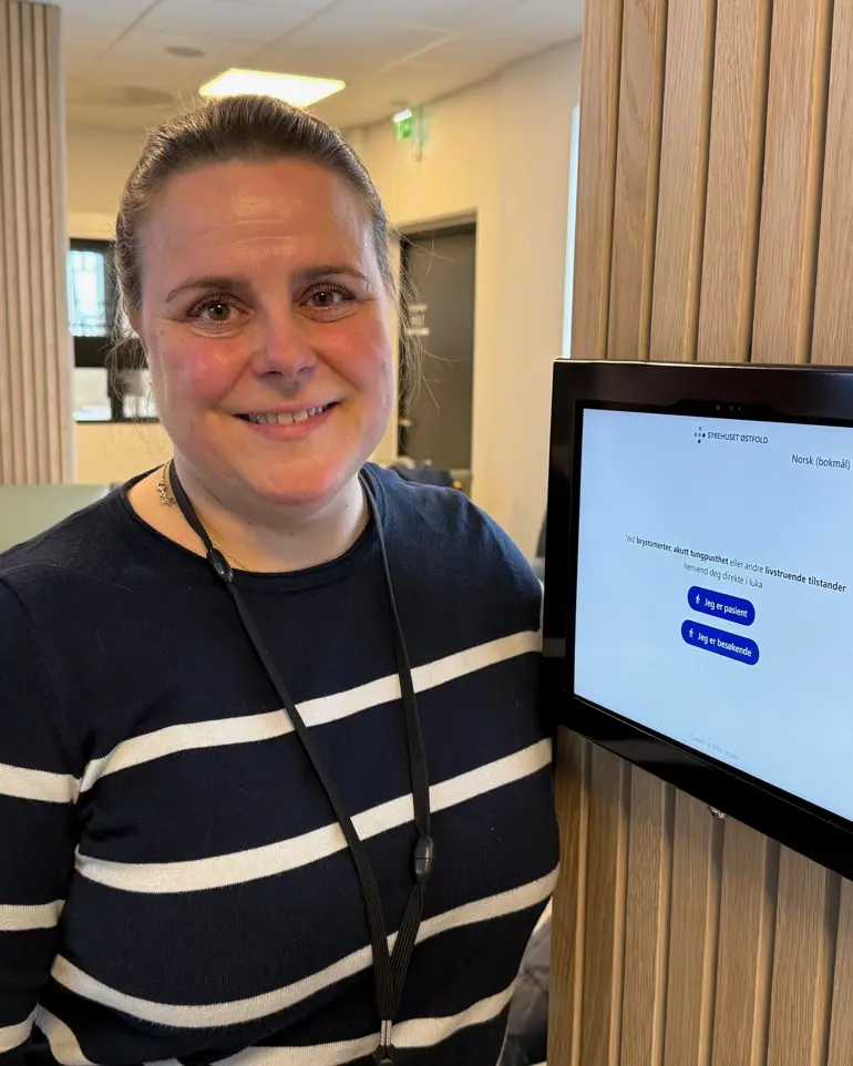 En mann som smiler foran en skjerm