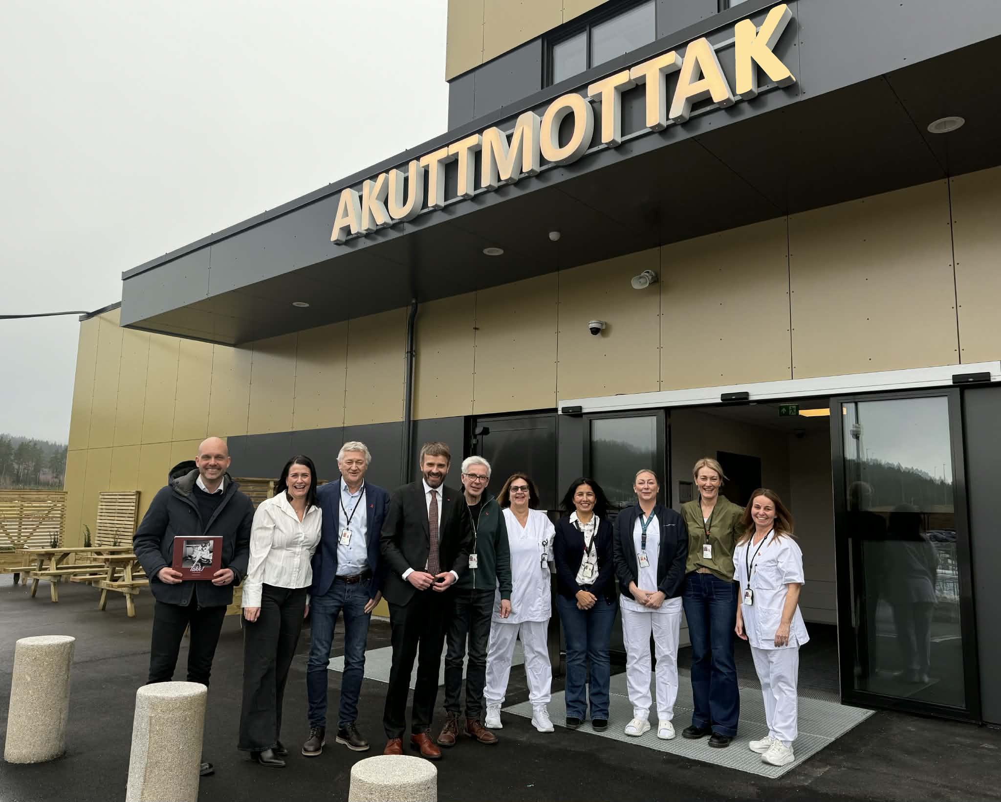 En gruppe mennesker som poserer for et bilde foran en bygning