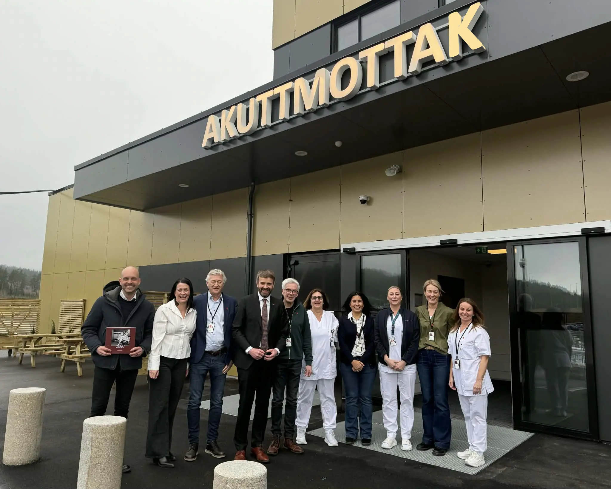 En gruppe mennesker som poserer for et bilde foran en bygning