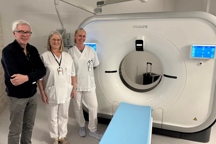 Noen få personer som står ved siden av en vaskemaskin