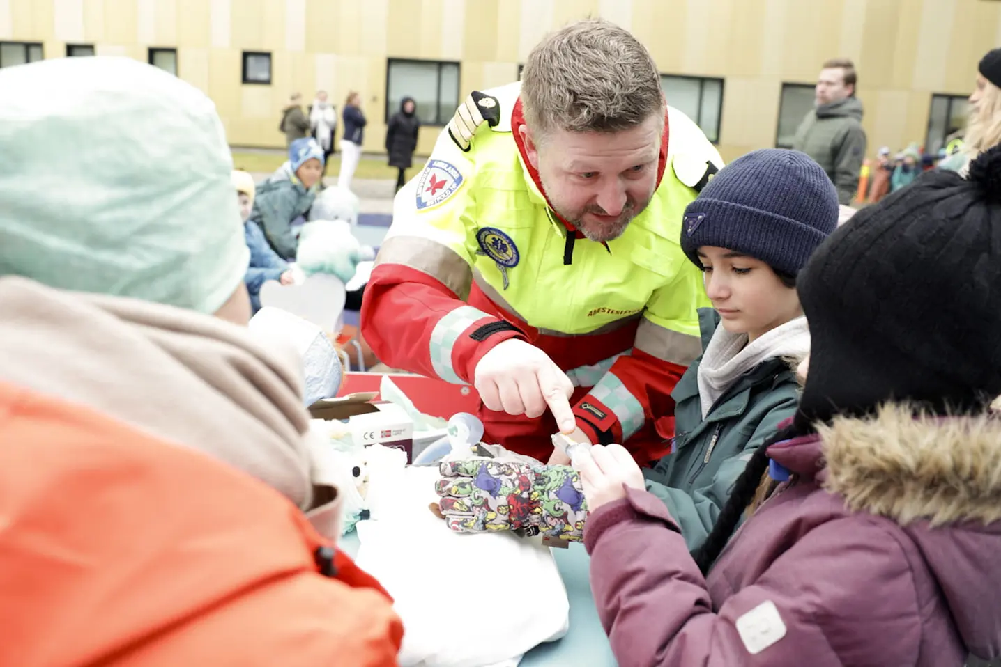 En person og et barn ved et bord med en gruppe mennesker