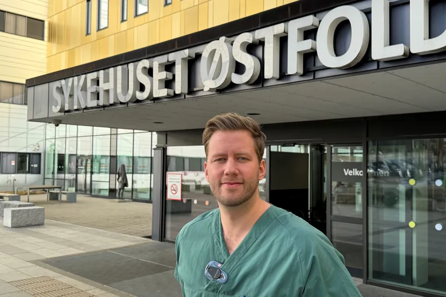 En mann som står foran en bygning