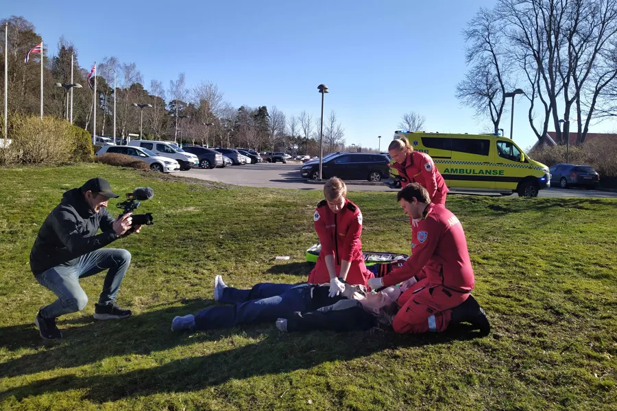 Simulering av at en person har fått hjertestans og ambulanse er tilkalt. F.v. Hallvard Mørk Tvete, Patrik Levente Bora, Henriette Lindseth Hansen og Jonas Feldt Gulbrandsen. Pasienten spilles av Marion Eilertsen Mossing.