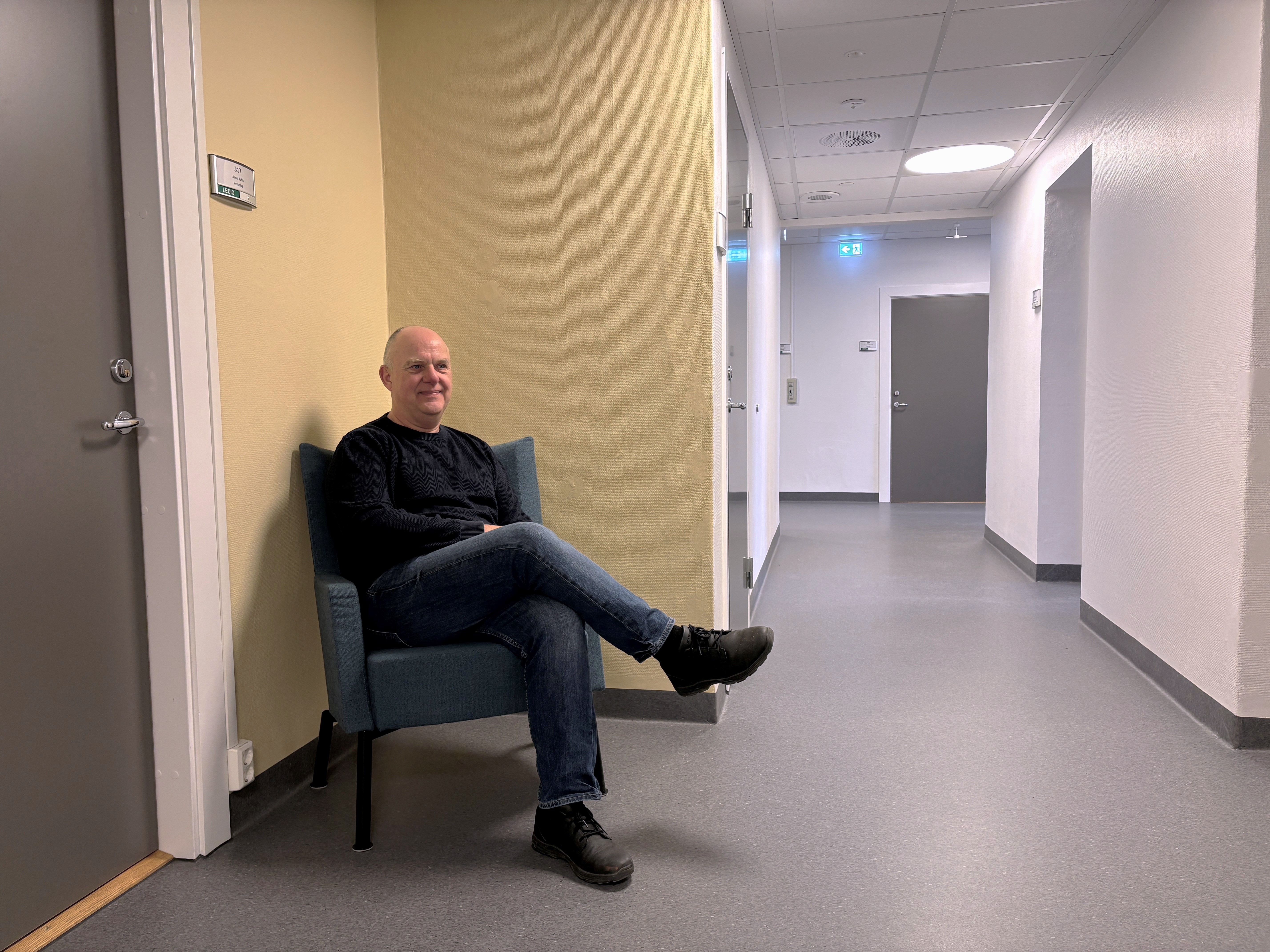 Vegg som er malt med en gulfarge. Gøran Fransson i sitter i en stol foran veggen.