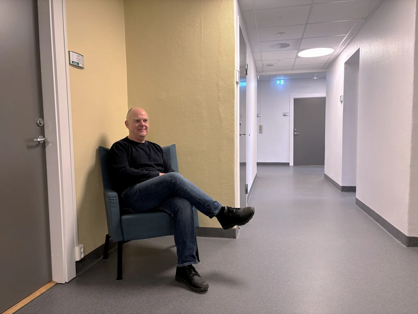 Vegg som er malt med en gulfarge. Gøran Fransson i sitter i en stol foran veggen.