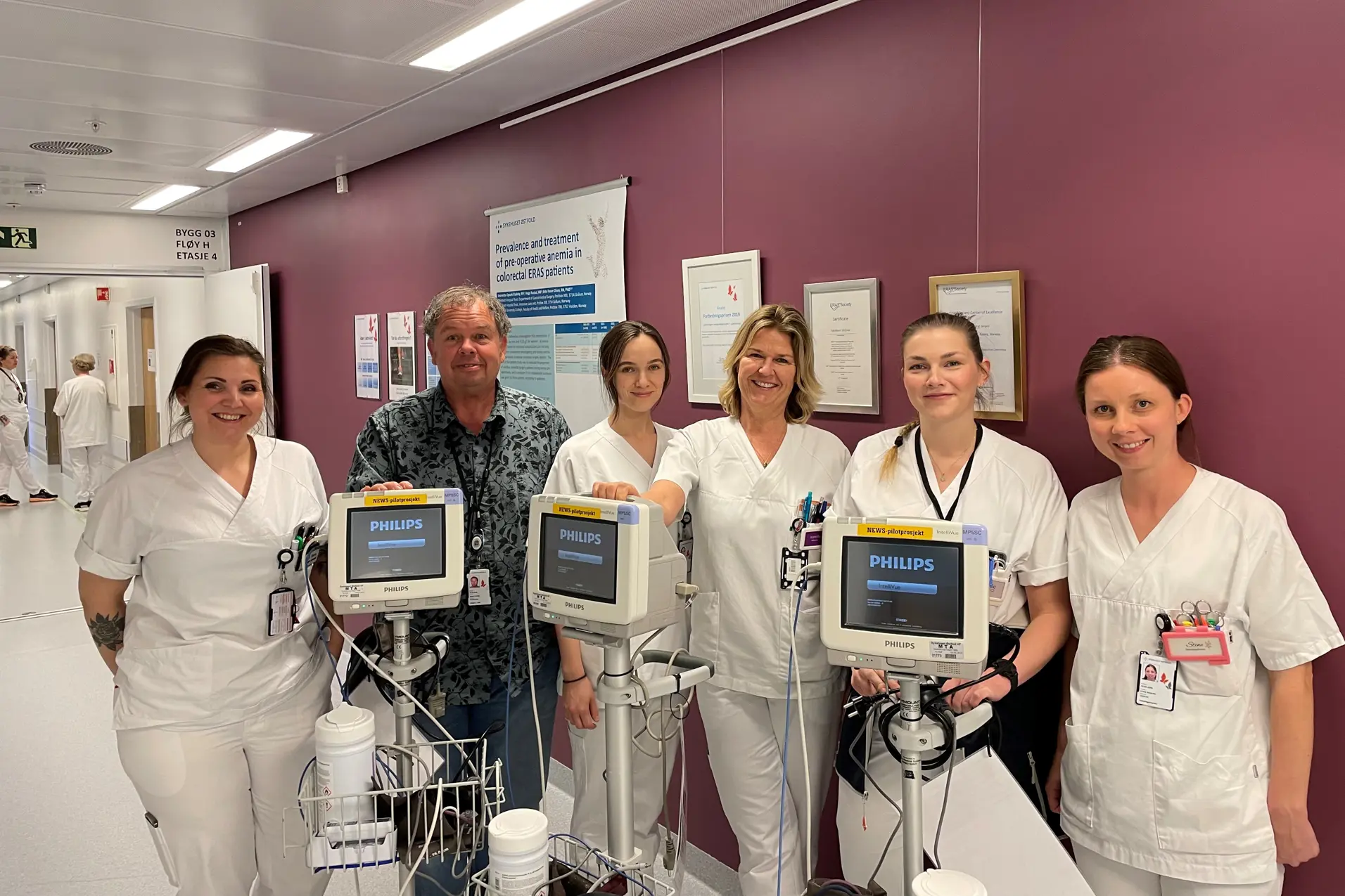 En gruppe mennesker i hvite laboratoriefrakker som holder en enhet