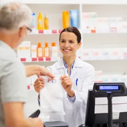 En lege som viser en pasient noe på datamaskinen