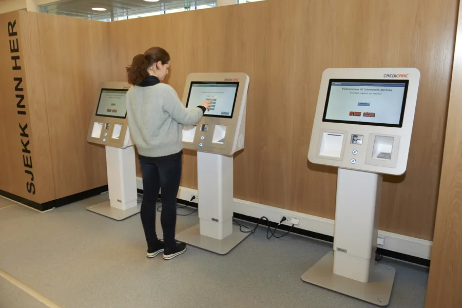 Kvinne ved selvinnsjekksautomat på Kalnes