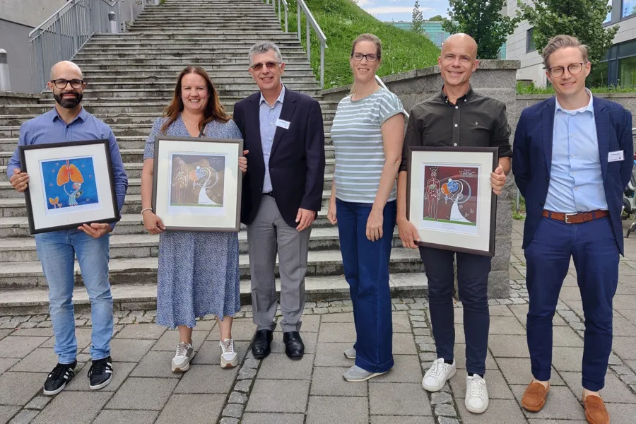 En gruppe mennesker som holder innrammede bilder