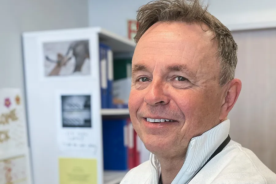 En mann som smiler til kameraet