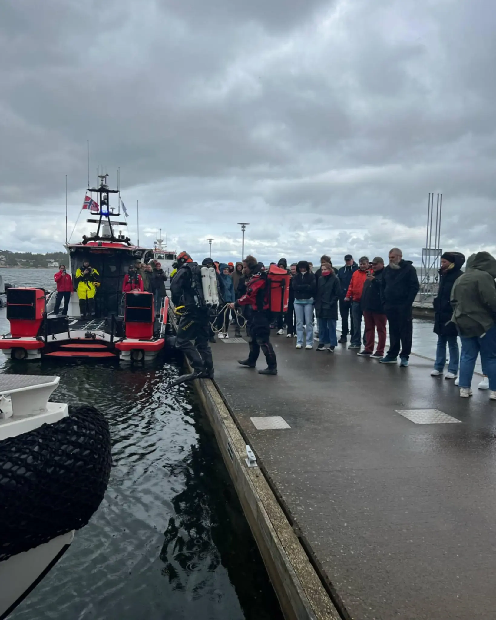 En gruppe mennesker som står på en brygge