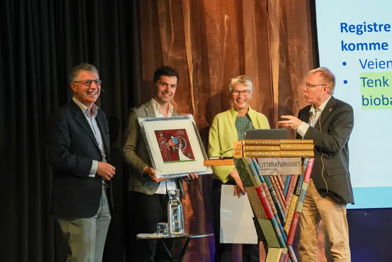 En gruppe mennesker som holder en plakett