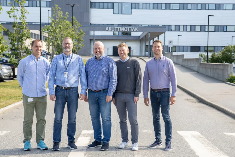 En gruppe menn som står foran en bygning