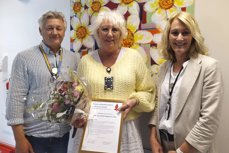 Seksjonsleder Elisabeth Nilsen Holm i midten mottok prisen på vegne av poliklinikkområde 4. Prisen ble delt ut av administrerende direktør Helge Stene-Johansen (t.v.) og hovedverneombud Anette Louise Børresen (t.h.).