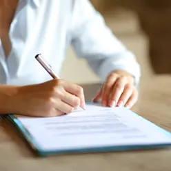 En person som skriver på et stykke papir