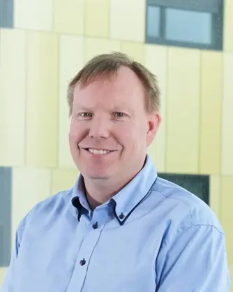 En mann som smiler til kameraet