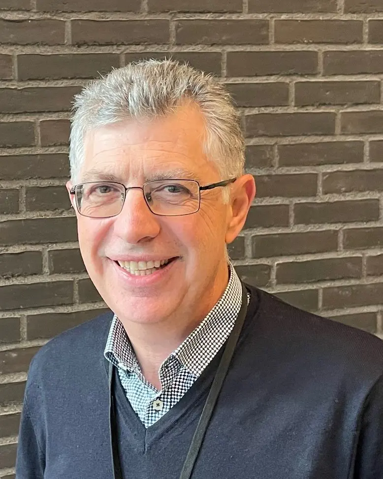 En mann som smiler til kameraet