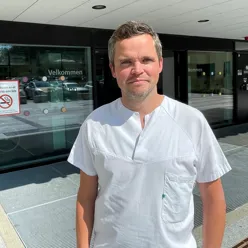 En mann som står foran en glassdør