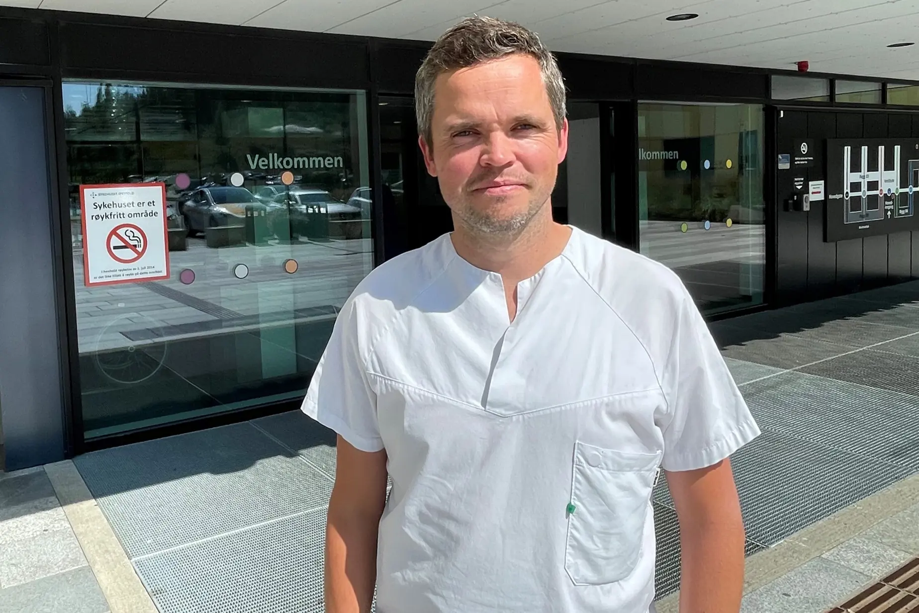 En mann som står foran en glassdør