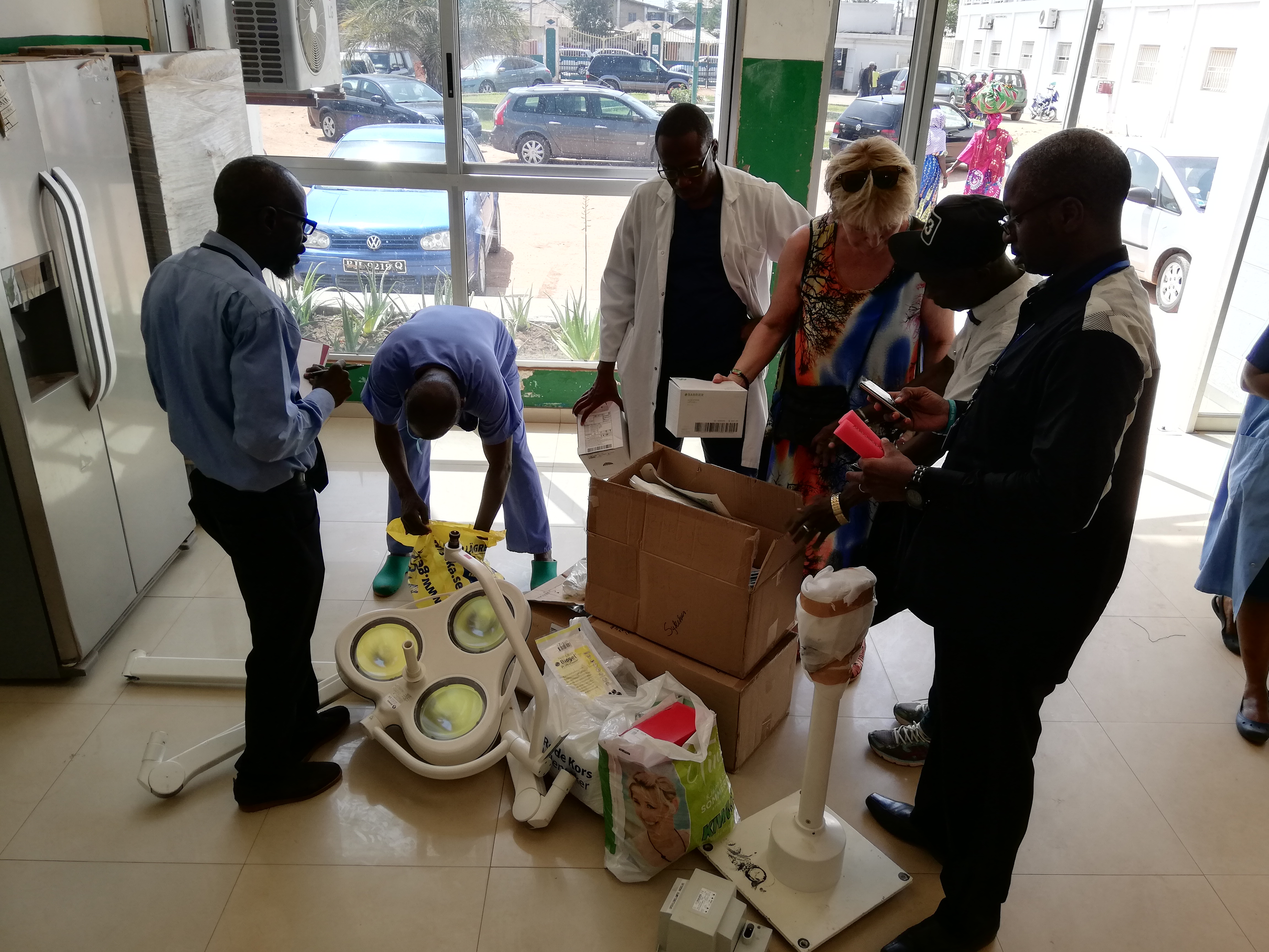 En gruppe mennesker som pakker ut utstyr og operasjonslampe på et sykehus i Gambia