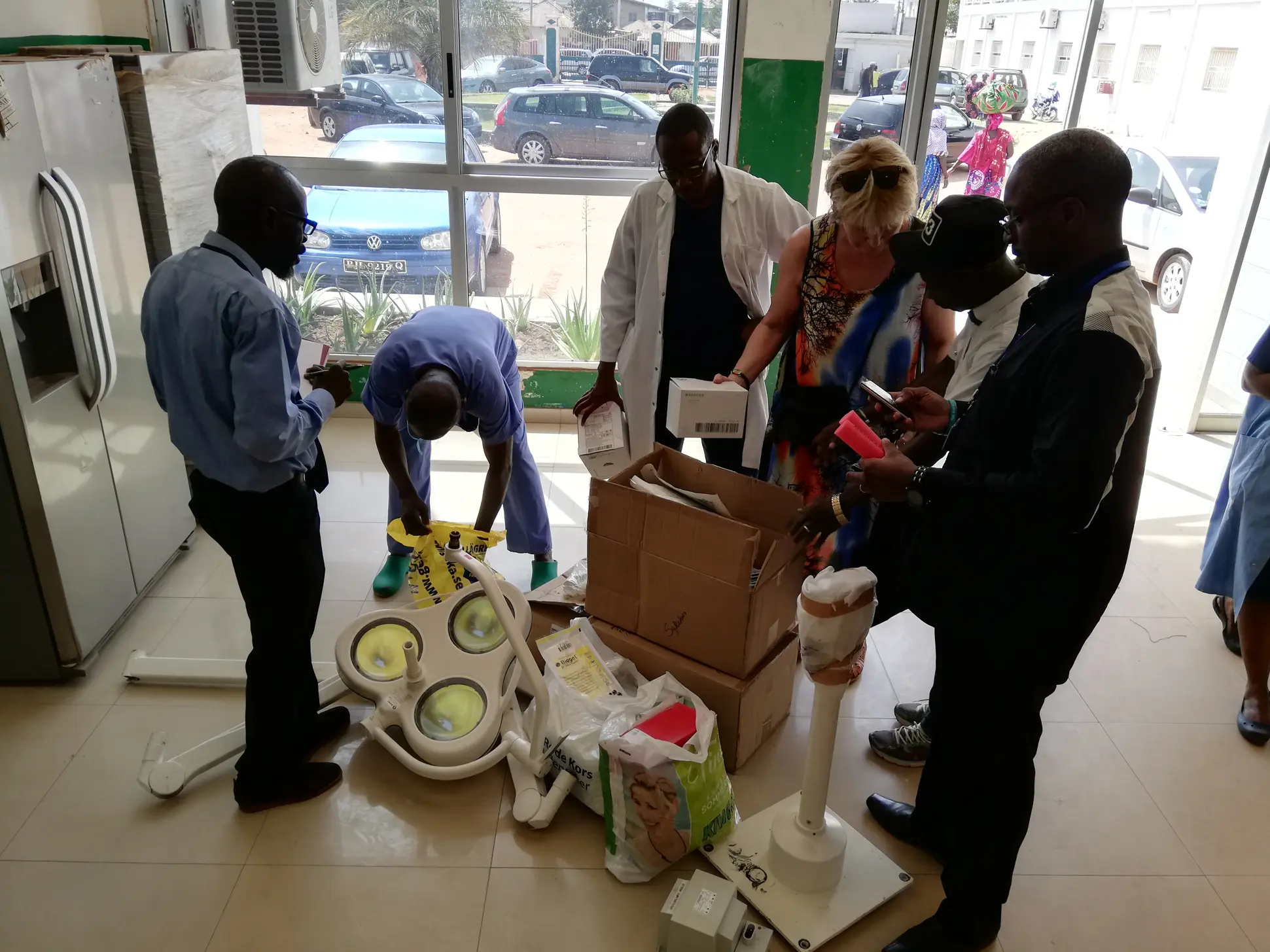 En gruppe mennesker som pakker ut utstyr og operasjonslampe på et sykehus i Gambia