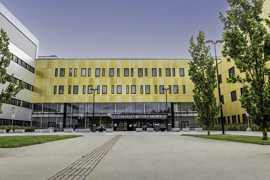 En stor bygning med en gate og trær foran den