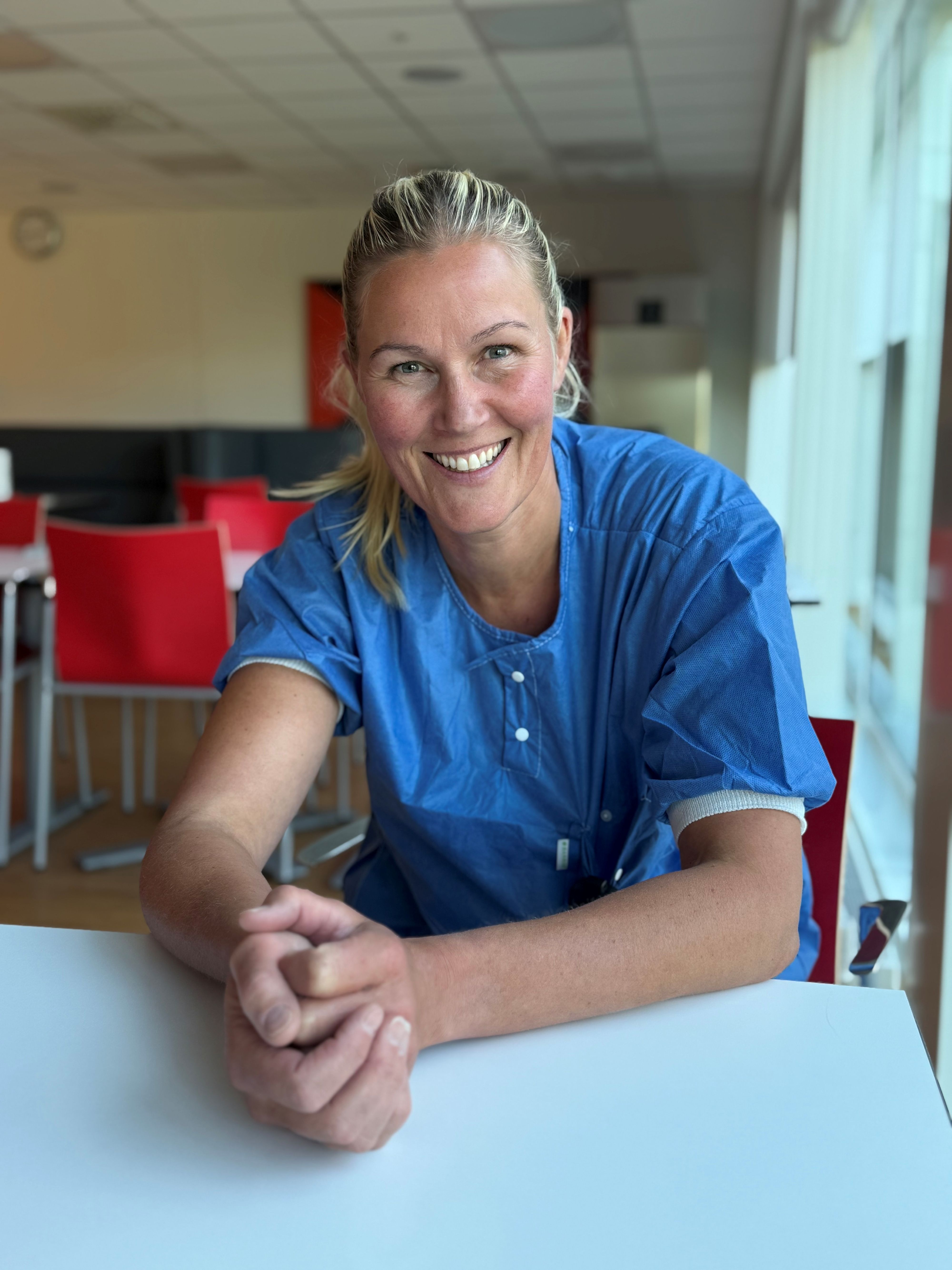 Marianne Holme sitter ved et bord i kantina på Kalnes