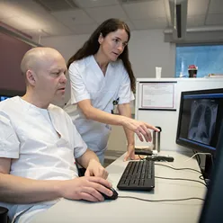 Radiolog og radiograf ser på en skjerm