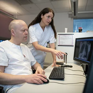 Radiolog og radiograf ser på en skjerm