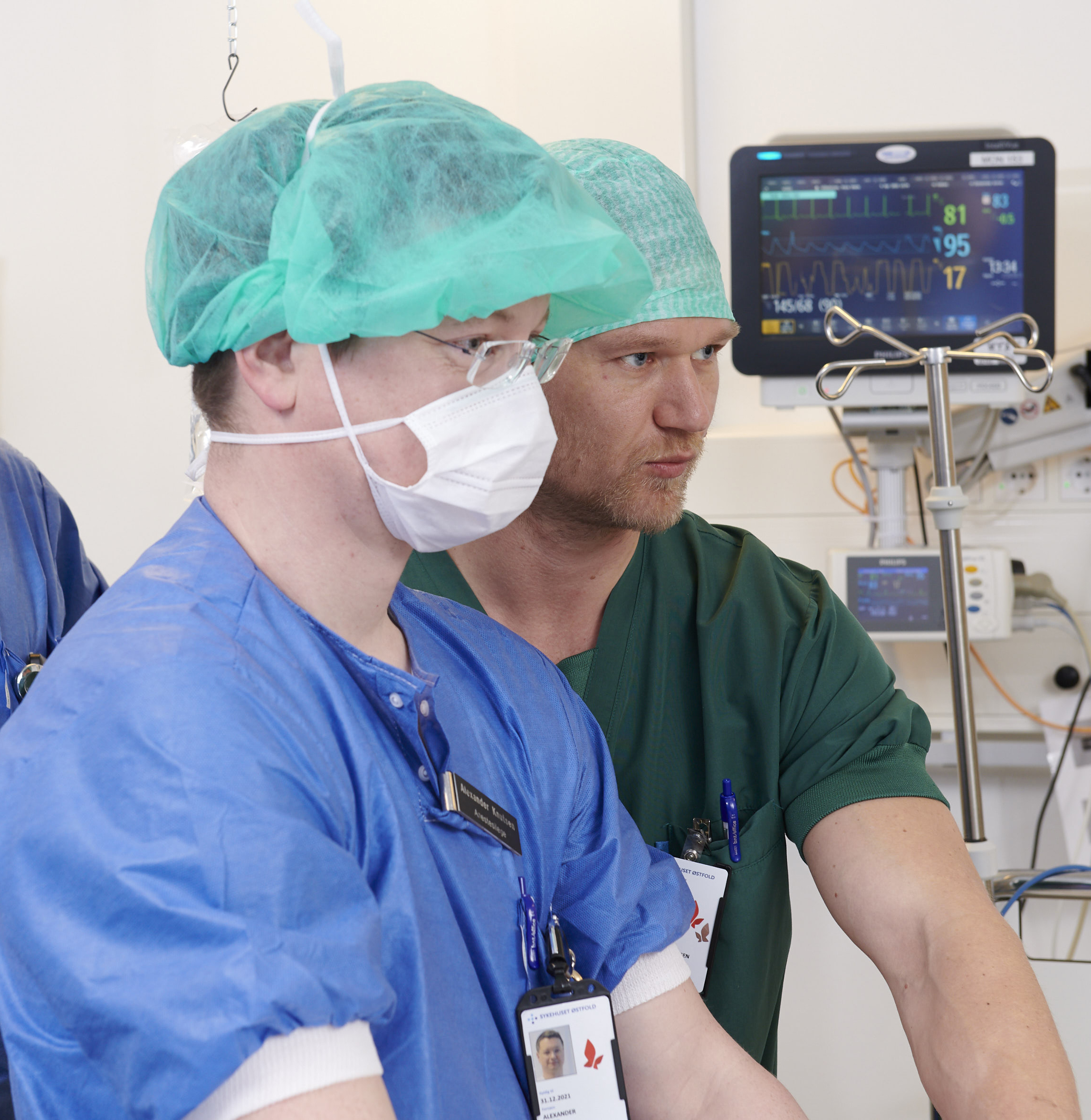 En mann iført maske og en kirurgisk skrubb