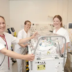 Lege og sykepleiere med baby i kuvøse