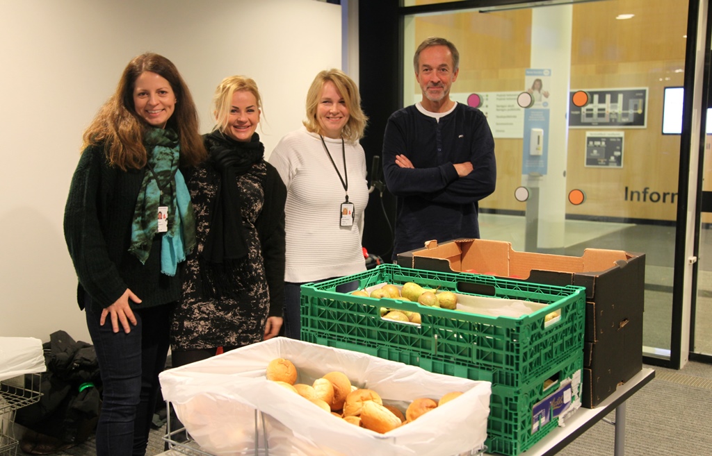 En gruppe mennesker som står ved siden av et bord med smultringer