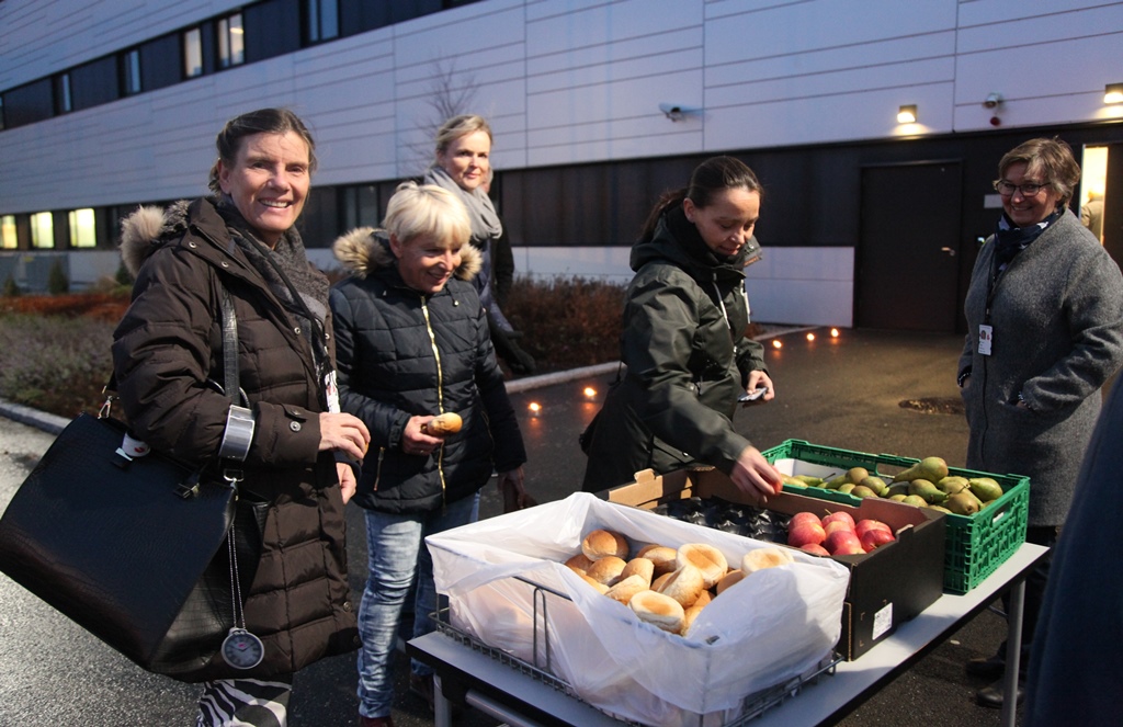 En gruppe mennesker som står ved siden av et bord med mat