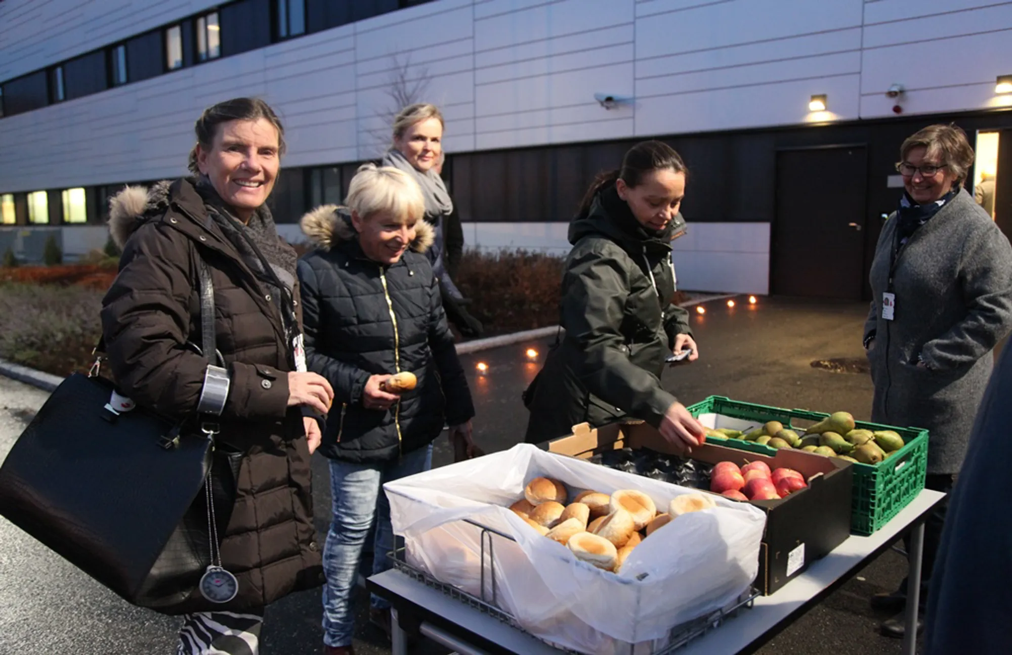 En gruppe mennesker som står ved siden av et bord med mat