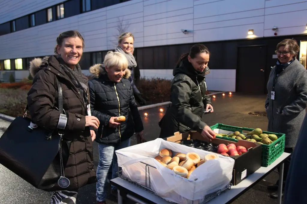 En gruppe mennesker som står ved siden av et bord med mat