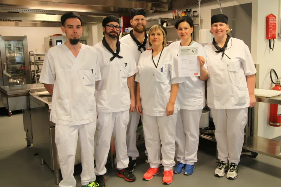 En gruppe mennesker iført hvite labfrakker og svarte masker