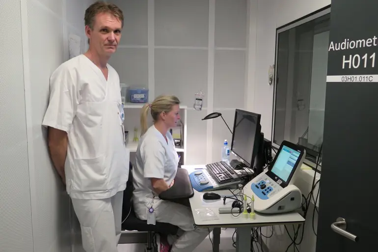 En mann og en kvinne i et rom med datamaskiner