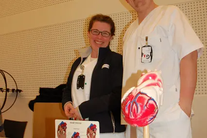 En mann og en kvinne i hvite frakker som står ved siden av et bord med en rakettmodell