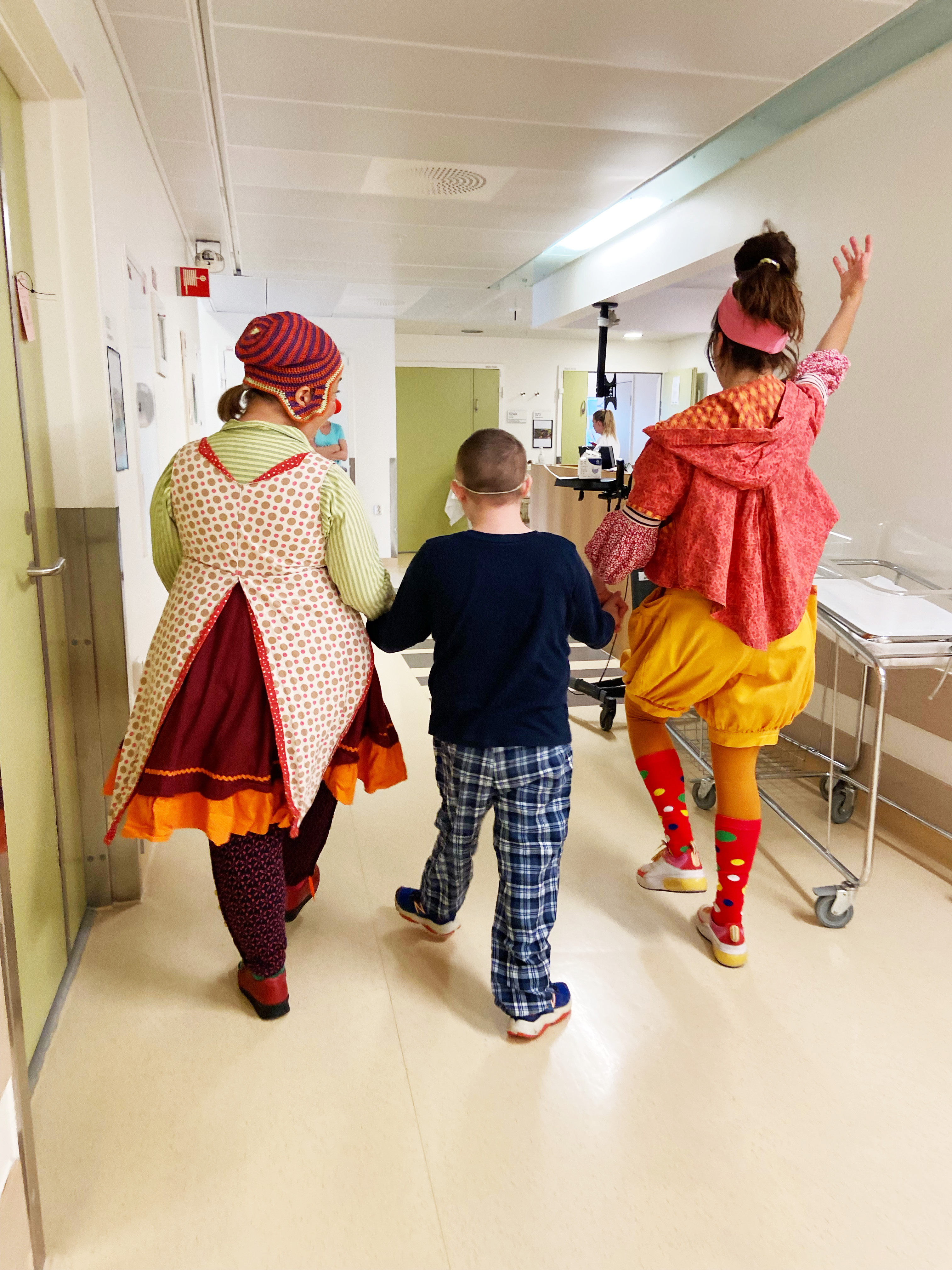 2 sykehusklovner sammen med en gutt i en gang