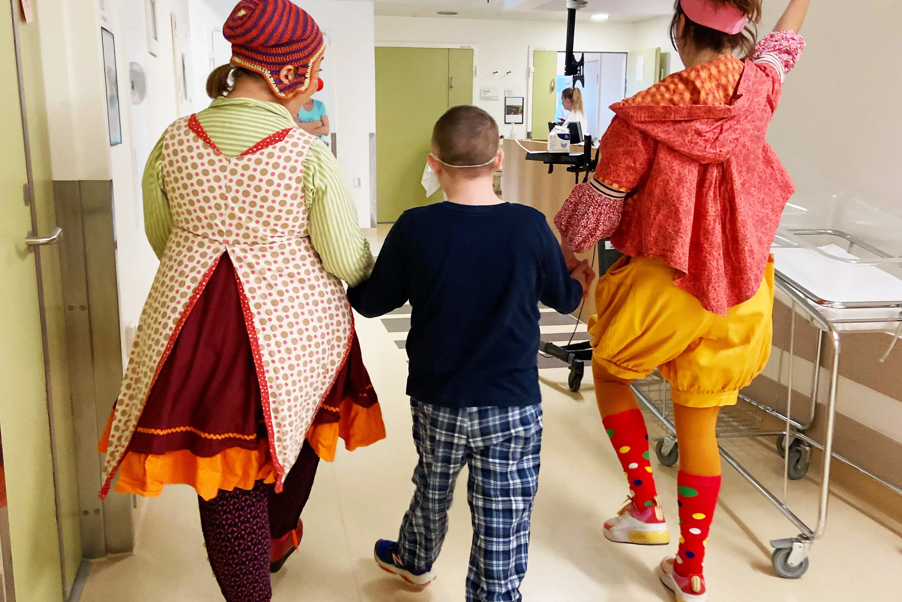 2 sykehusklovner sammen med en gutt i en gang